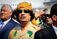 القذافي مرتديًا زيًا عسكريًا واضعًا عليه خريطة قارة أفريقيا