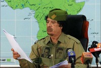 القذافي خلال إلقاءه خطابًا في التلفزيون مرتديًا قميص مطبوع عليه عبد الناصر وأحمد بن بلة
