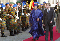 القذافي خلال استقبال رسمي له مرتديًا زيًا أزرقًا بالكامل غير تقليدي 
